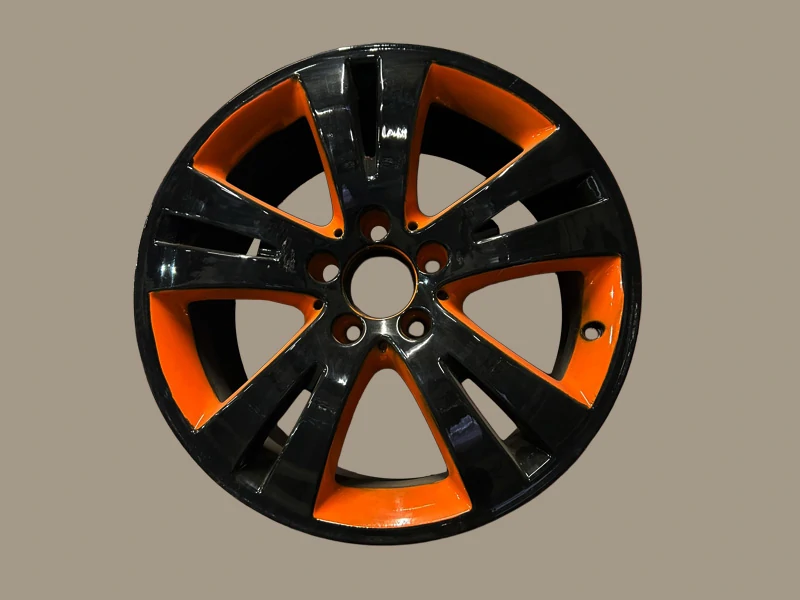 Personnalisation de la peinture d'une jante aux couleurs noires et orange vifr